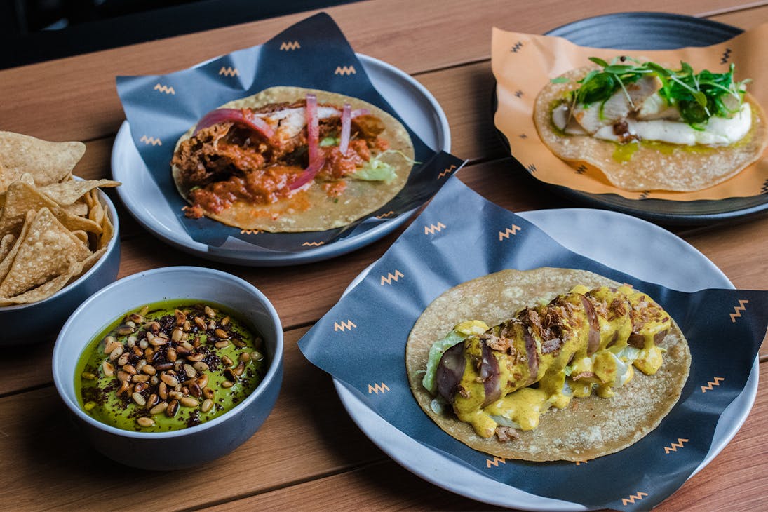 several plates of tacos and chips